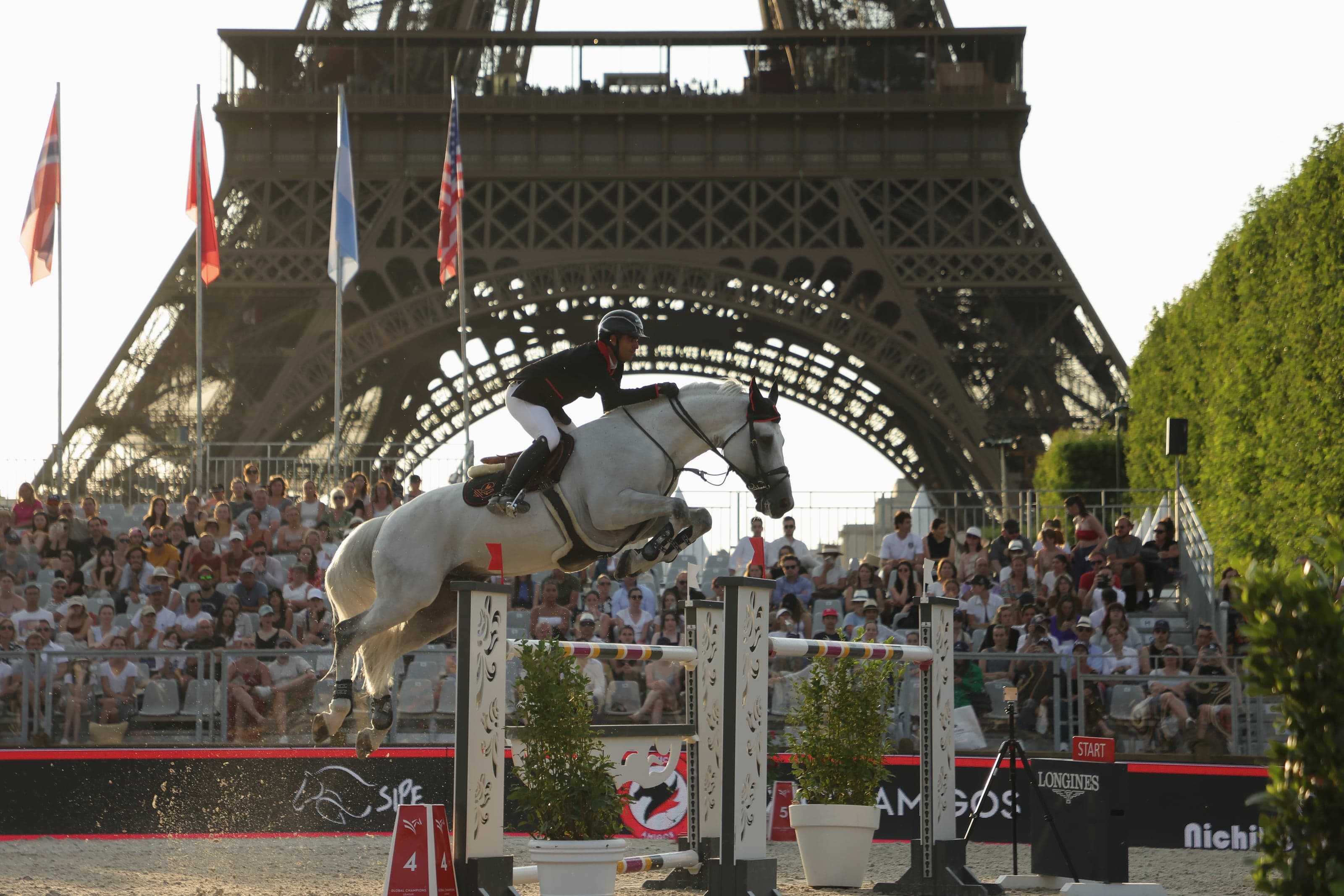 Nicolás Pizarro salta con un caballo tordillo bajo los arcos de la Torre Eiffel, en el Longines Global Champions Tour de París, 2023.